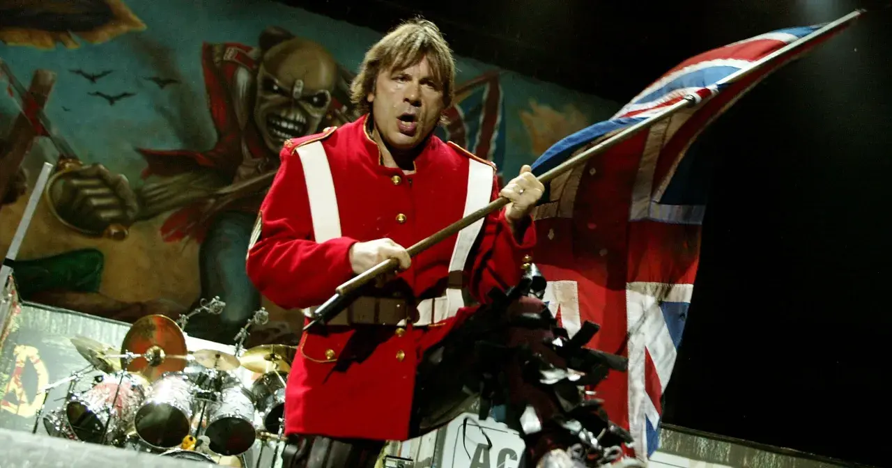 Bruce Dickinson z zespołu Iron Maiden na scenie z flagą Wielkiej Brytanii i Eddie'm w tle.