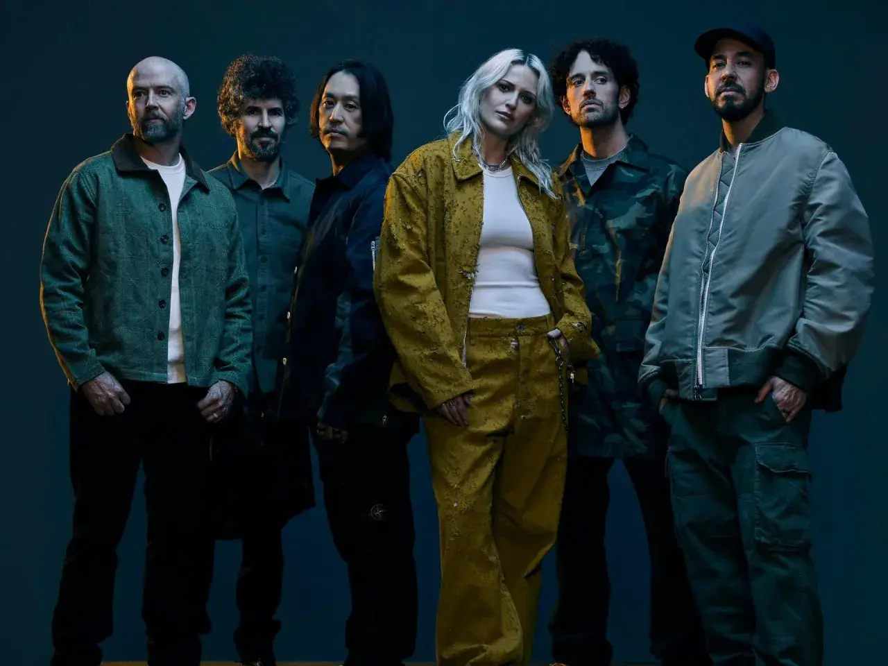 Sześciu członków zespołu, w tym wokalistka, pozuje do zdjęcia. Fani Linkin Park Polska z pewnością rozpoznają swoich idoli.