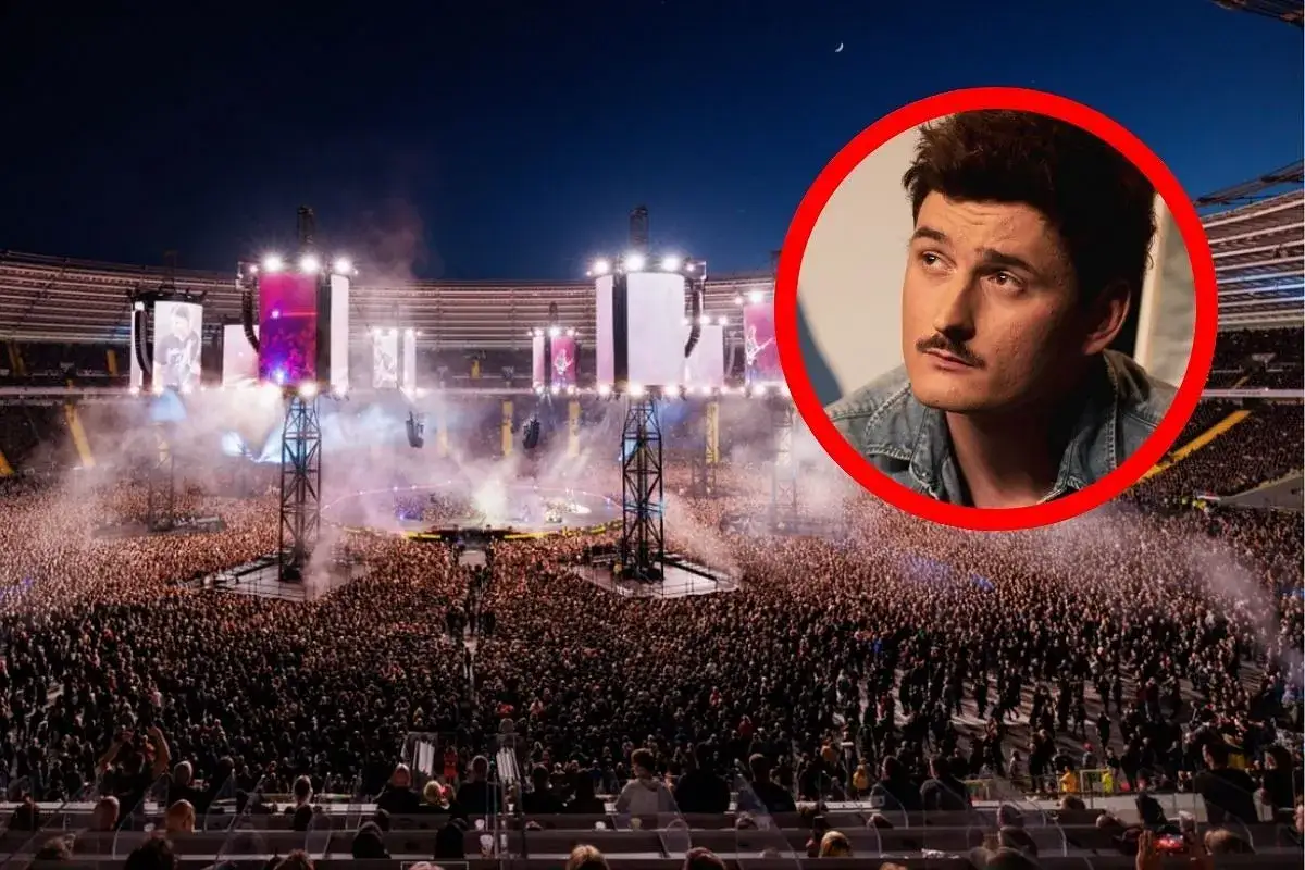 Gwiazda z wąsem w czerwonym okręgu na tle największego koncertu w Polsce. Tysiące fan&oacute;w na stadionie, światła i dym.