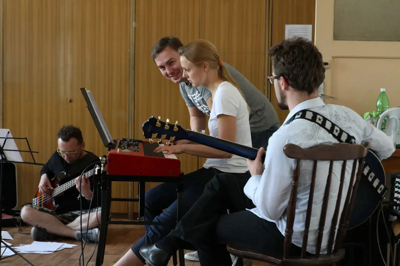 Zespół ćwiczy, szukając fajna nazwa dla zespołu muzycznego. Klawiszowiec gra, basista i gitarzysta czekają na swoją kolej.